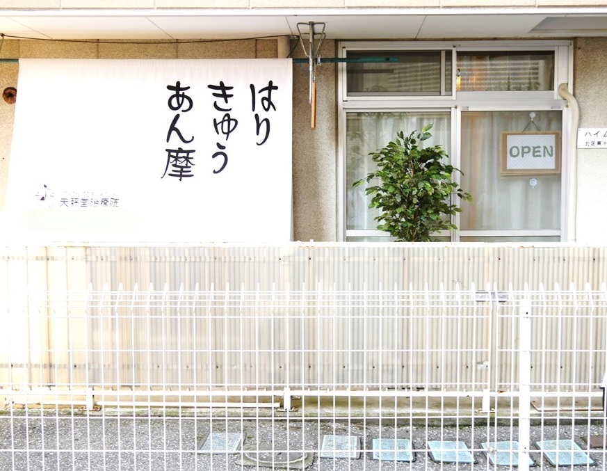 H外から見ると大きな垂れ幕にはりきゅうあん摩の文字。手前の白い金網の柵を開けて(押す)入ってきてくださいね。自転車は柵の中に入れていただきますようお願いします。